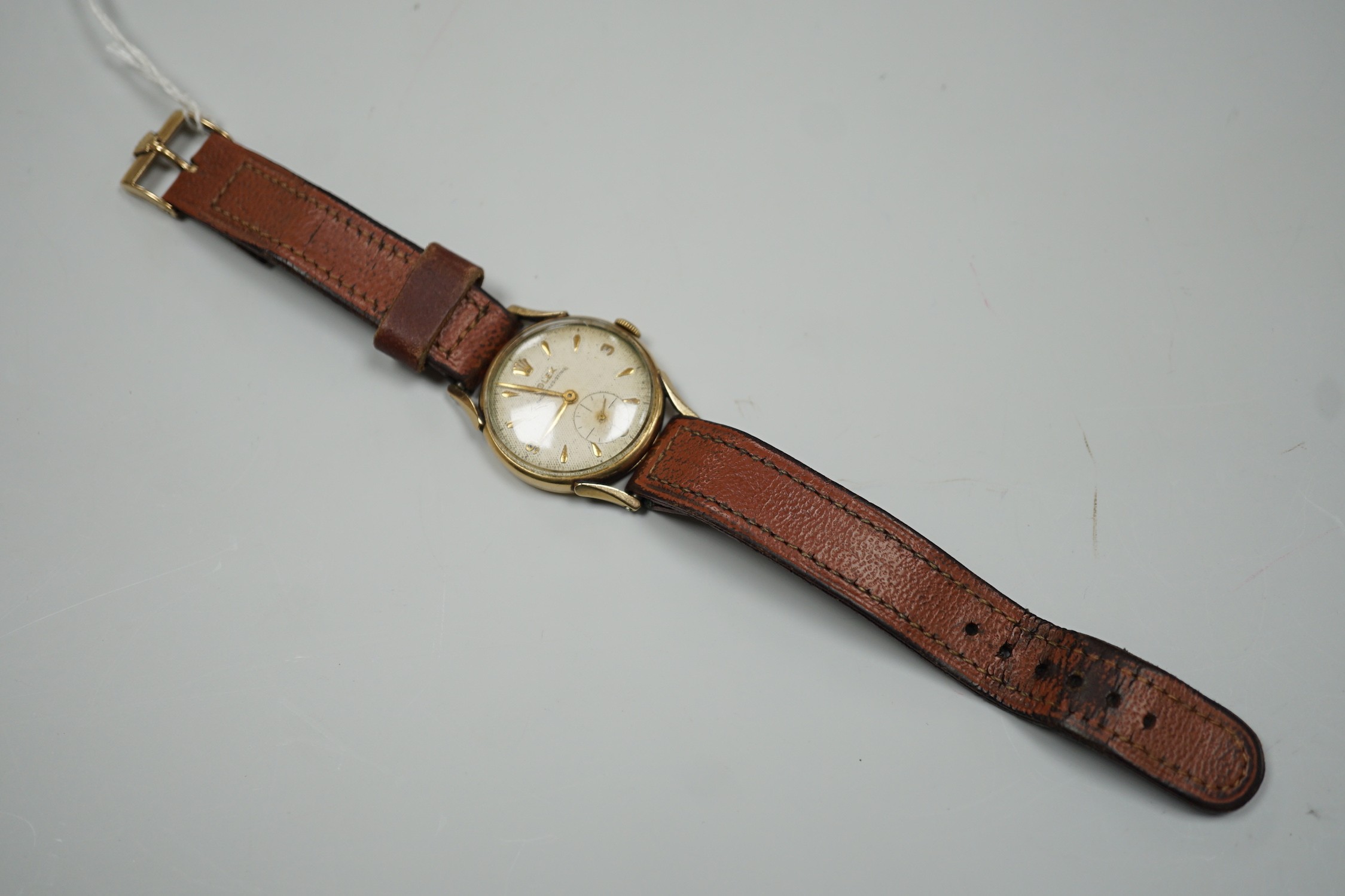 A gentleman's mid 1950's 9ct gold Rolex shock-resisting manual wind wrist watch, with baton and Arabic numerals and subsidiary seconds, on later associated leather strap, case diameter 32mm